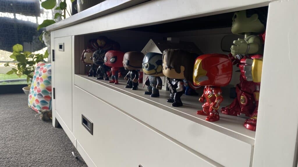 funko pop figures lining up inside a tv stand