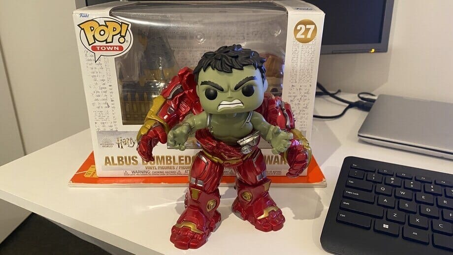 red and green colored Hulkbuster funko pop in front of albus dumbledore pop on a work desk
