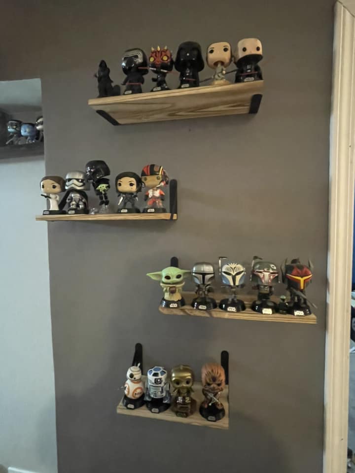 4 floating shelves mounted on a wall holding funko pops